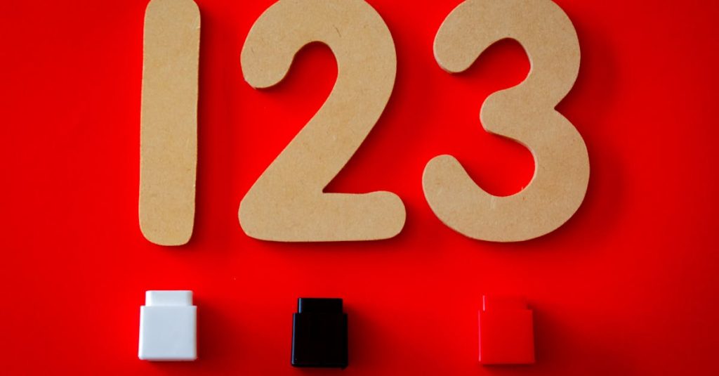 Close-up of wooden numbers 1, 2, 3 with colorful blocks on a vibrant red background.