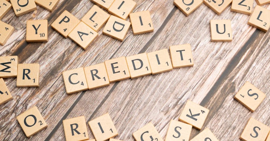 Wooden letter tiles arranged to spell 'CREDIT' on a rustic table background.