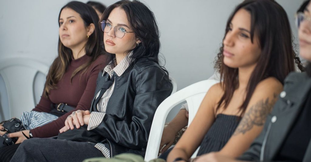 Focused individuals attending an indoor seminar, showcasing engagement and learning.