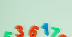 Bright plastic numbers 0-9 on a green background with ample copy space.