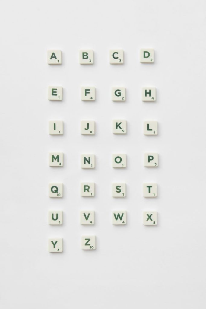 Scrabble letter tiles arranged in alphabetical order on a white background.