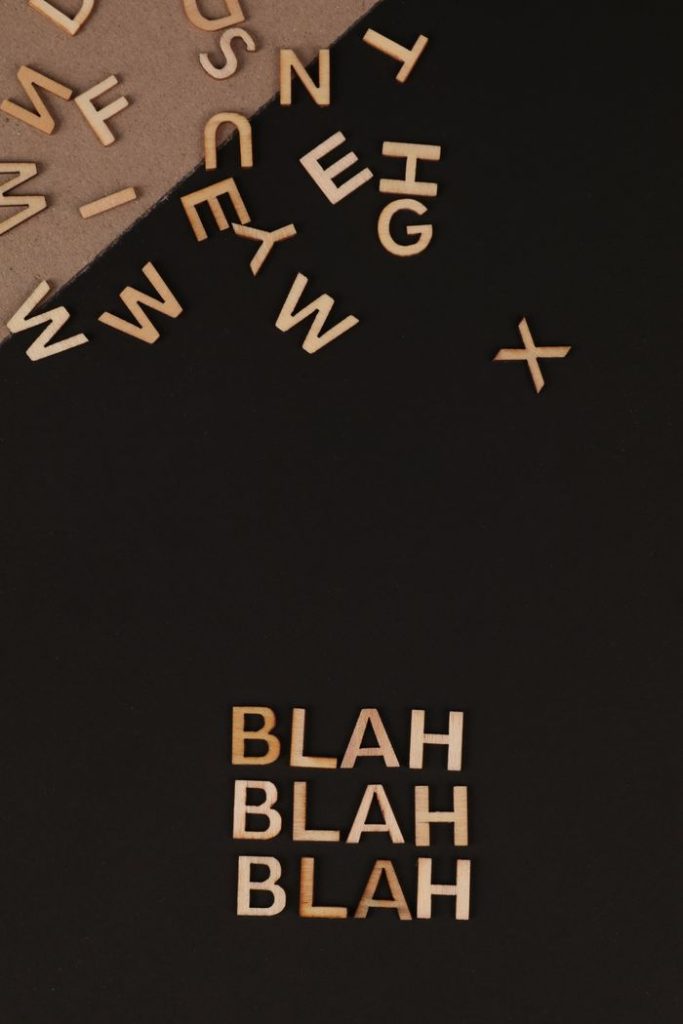 Artistic arrangement of wooden letters on a dark flat lay with a conceptual theme.
